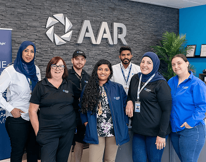 A team in front of an AAR logo sign